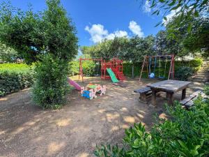 a playground with a picnic table and a bench at Appartamenti Casa Rossi in Capoliveri