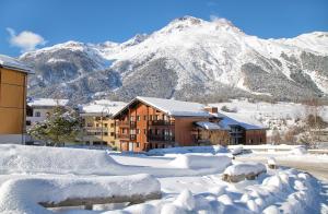a city covered in snow with a mountain in the background at Balcons B 024 - PARC NAT VANOISE appart 6 pers in Val Cenis +8 photos