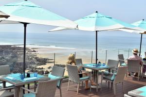 a couple sitting at a table with an ocean view at Watersmeet Hotel in Woolacombe