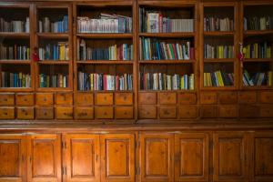 a library filled with wooden cabinets filled with books at Tenuta Arangio Agriturismo Vendicari in Casa Maccari