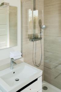 a bathroom with a shower and a white sink at Weidestr 18 Wohnung 2 ( Captains' finest) in Heiligenhafen