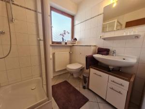 a bathroom with a sink and a toilet and a shower at Gästehaus Radlerhof in Gstadt am Chiemsee +34 photos
