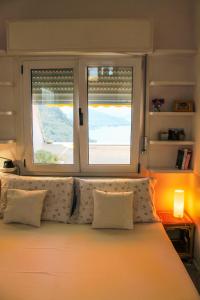 Un dormitorio con una cama grande con dos ventanas. en Terrazza sul Lago, en Luino