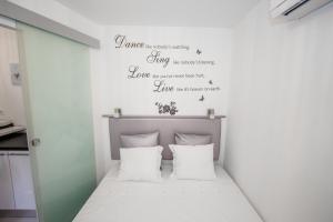 um pequeno quarto com uma cama com almofadas brancas em Luxury Studio Apartment White Sensation em Vodice