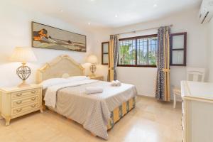 Un dormitorio con una cama grande y una ventana. en Lovely Villa Las Palmeras, en Marbella 20 fotos más