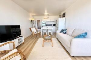 a living room with a white couch and a table at Vue mer 180 - Charmant T3 - Coup de coeur garanti in Ploemeur