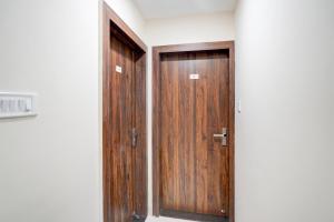 a pair of wooden doors in a room at Hotel O Lakshya in Indore