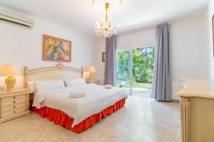 a bedroom with a large bed and a chandelier at Beautiful Villa La Caracola in Marbella +21 photos