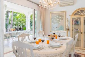 a dining room with a table with chairs and a chandelier at Beautiful Villa La Caracola in Marbella