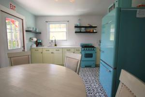 a kitchen with a table and a blue refrigerator at Cozy Cottage House - Pool & Hot Tub in Ferndale