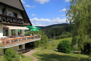 people sitting on the balcony of a hotel at Café Pension Pfaus Heidburg in Mühlenbach
