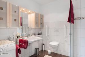 a white bathroom with a sink and a toilet at Ferienwohnung Paffendorf in Gutach +28 photos