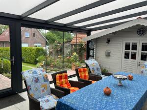 a patio with a blue table and some chairs at Ferienwohnung Klatto in Südbrookmerland