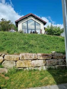a house on top of a hill with a stone wall at Ferienhaus Sanddornweg 06 mit Klimaanlage & E-Ladestation in Mistelgau