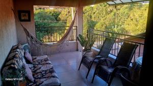 a balcony with two chairs and a balcony with a window at Edícula Recanto das Palmeiras in Uberaba
