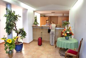 a woman standing in a kitchen with a suitcase at Gasthof Lerner in Freising