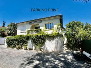 een wit huis met een hek en struiken bij Villa Etoile Cannes in Cannes