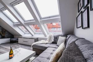 a living room with a couch and some windows at Luxury City Loft Modern and Elegant in Bratislava