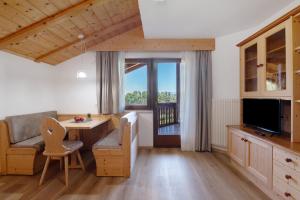 a living room with a table and a chair and a television at Aldeinerhof in Aldino