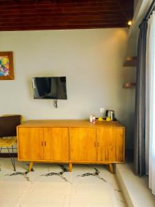 a wooden cabinet with a television on a wall at Japa Guesthouse in Canggu