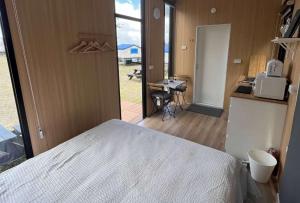 ein Schlafzimmer mit einem Bett und eine Küche mit einem Schreibtisch in der Unterkunft A Kuei Cottage X by Tiny Away in Wufeng