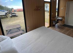 ein Schlafzimmer mit Bett und Blick auf ein Feld in der Unterkunft A Kuei Cottage X by Tiny Away in Wufeng