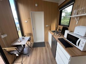 eine kleine Küche mit Tisch und Mikrowelle in der Unterkunft A Kuei Cottage X by Tiny Away in Wufeng