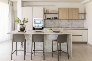a kitchen with a large marble island with chairs at Syvana Exquisite Villas in Syvota
