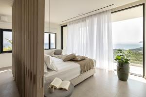 a bedroom with a bed and a large window at Syvana Exquisite Villas in Syvota +101 photos