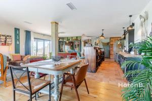 a kitchen and living room with a table and chairs at Cottage Mamie Yvette Private Spa in Blanc