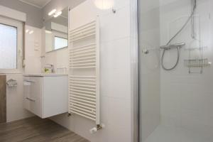 une salle de bain blanche avec une douche et un lavabo dans l'établissement Madleen, à Wieck 6 autres photos