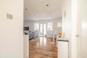 a kitchen and living room with white walls and wood floors at Host & Stay - Meadow Way in Windsor