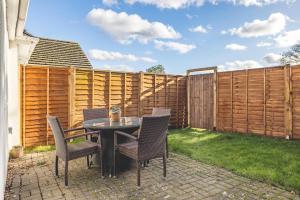 a patio with a table and chairs and a fence at Host & Stay - Meadow Way in Windsor