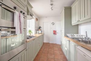 a kitchen with white cabinets and a tile floor at Host & Stay - Meadow Way in Windsor
