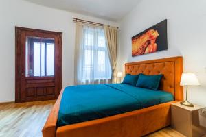 a bedroom with a large bed with a blue blanket at Old City Lux 2 in Braşov