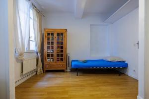 a bedroom with a blue bed and a window at Maison Saint Julien in Vence
