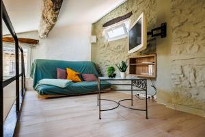 a living room with a green couch and a table at Maison Saint Julien in Vence
