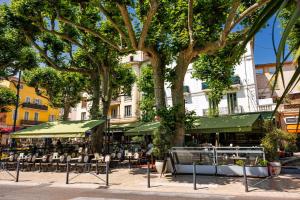 a group of tables and chairs under a tree at Maison Saint Julien in Vence
