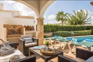 an outdoor patio with chairs and a swimming pool at Villa Viola Bosch Menorca in Cala'n Bosch