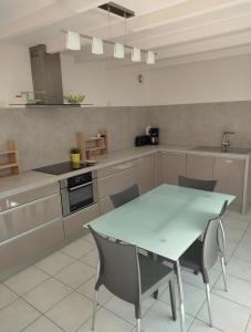 a kitchen with a table and chairs in it at Maison 4pers au calme vue Jardin in Roscoff