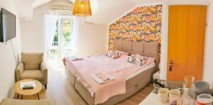 a small bedroom with a bed and a chair at Villa Kipre in Cavtat