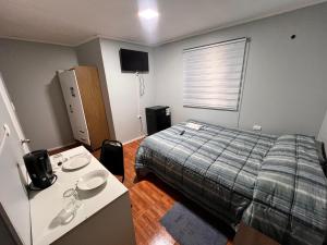 a bedroom with a bed and a table with a table at Oasis Mini Deptos in Calama