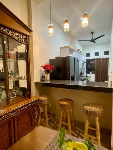 a kitchen with a bar with stools and a counter at Ndalem Suryo Guesthouse in Yogyakarta