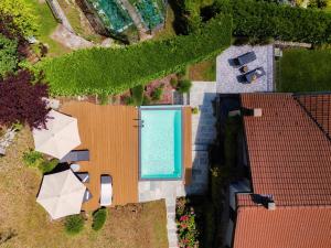 an overhead view of a swimming pool on a house with umbrellas at Villa Casasco - by MyHomeInComo in Casasco Intelvi