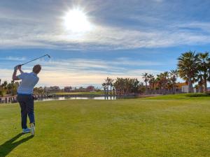 Un hombre balanceando un palo de golf en un campo de golf en Apartamento moderno cerca de la playa, aire acondicionado, 2 dormitorios, jardín común - ES-376-18, en Pulpí