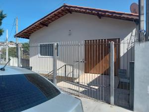 a fence in front of a house with a garage at Hospedagem Alvinópolis in Atibaia