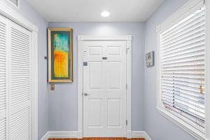 a white door in a hallway with windows at -Island Girl- Immaculate Gulf Front Duplex home in Fort Myers Beach +33 photos