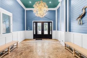 a hallway with blue walls and benches and a chandelier at -Island Girl- Immaculate Gulf Front Duplex home in Fort Myers Beach