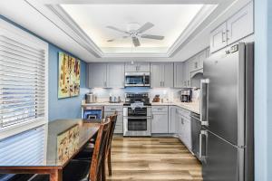 a kitchen with a table and a ceiling fan at -Warm Sands- Fantastic Gulf Front Duplex! home in Fort Myers Beach