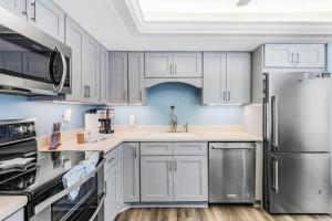 a kitchen with white cabinets and stainless steel appliances at -Warm Sands- Fantastic Gulf Front Duplex! home in Fort Myers Beach